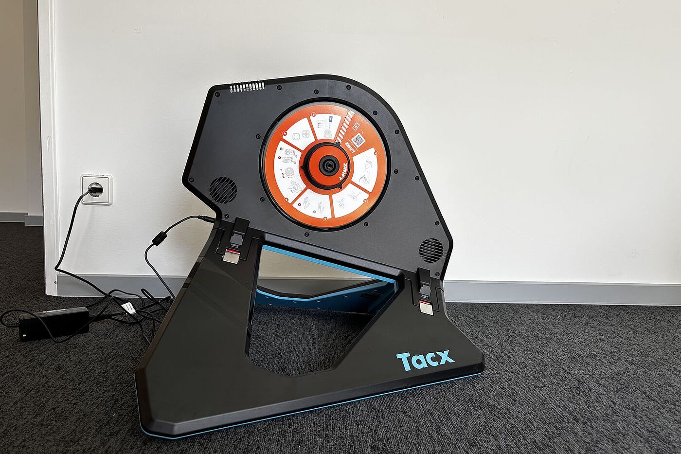 Neo aufgestellt Der Smarttrainer Tacx Neo 2T steht auf grauem Teppich vor einer weißen Wand.
